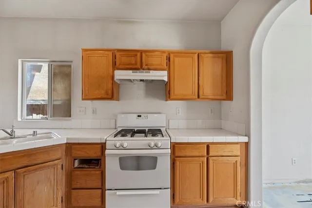 a kitchen with a stove a sink and a cabinets