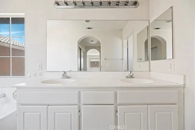 a bathroom with a double vanity sink and a mirror