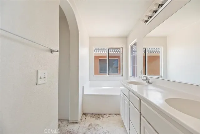 a bathroom with a tub sink and mirror