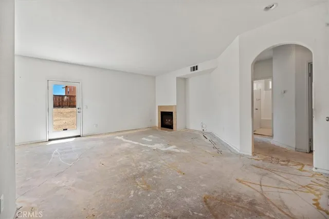 an empty room with a fireplace and cabinet