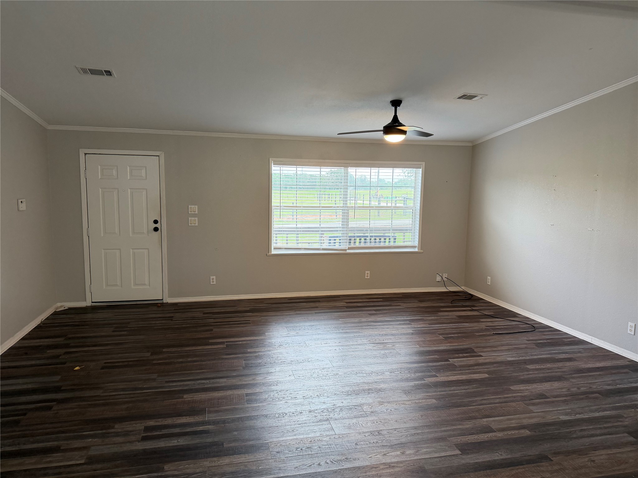29480 Skymac Ranch Road Hempstead, TX 77445 - Photo 7 of 11 an empty room with wooden floor chandelier fan and windows
