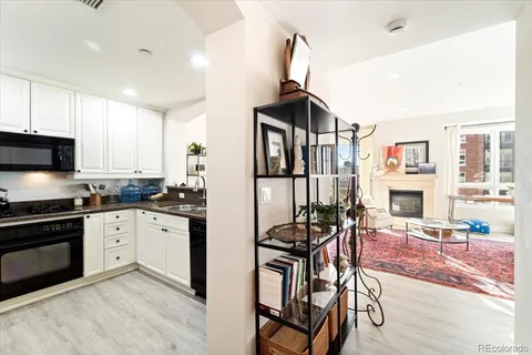 a kitchen with stainless steel appliances granite countertop a stove top oven a sink a dining table and chairs with wooden floor