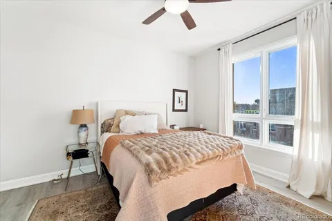 a bed sitting in a bedroom next to a window and a chandelier