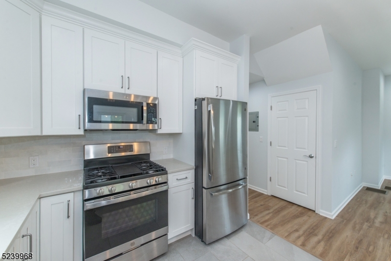68 Orchard Street, Unit 1 Summit, NJ 07901 - Photo 10 of 23 a kitchen with a refrigerator stove and white cabinets