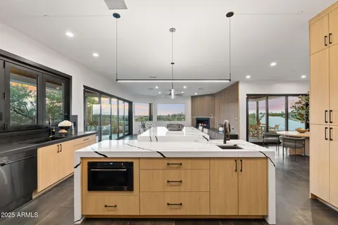 a room with stainless steel appliances kitchen island a large counter space a sink a stove and a window