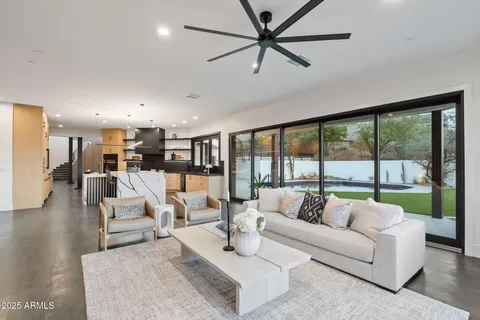 a living room with furniture wooden floor and a large window