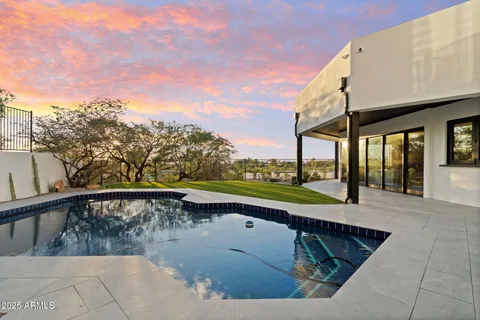 a view of swimming pool with a yard and mountain view in back