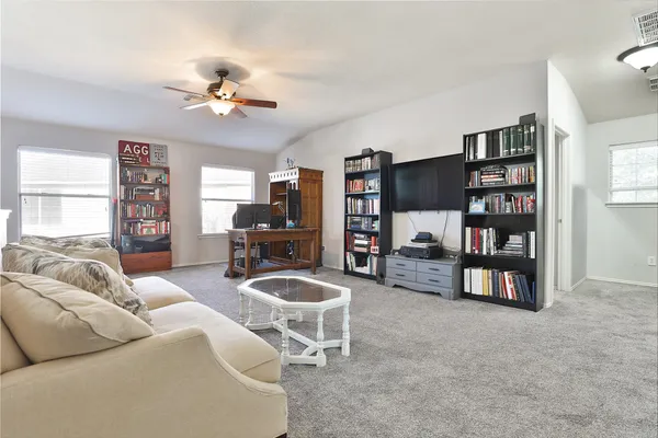 a bedroom with bed a flat tv screen and dresser