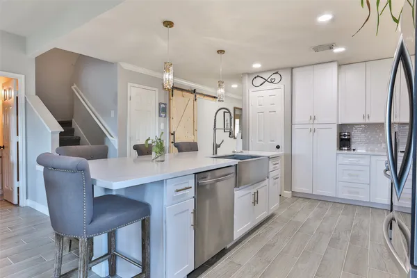 a large kitchen with stainless steel appliances sink a stove and a refrigerator