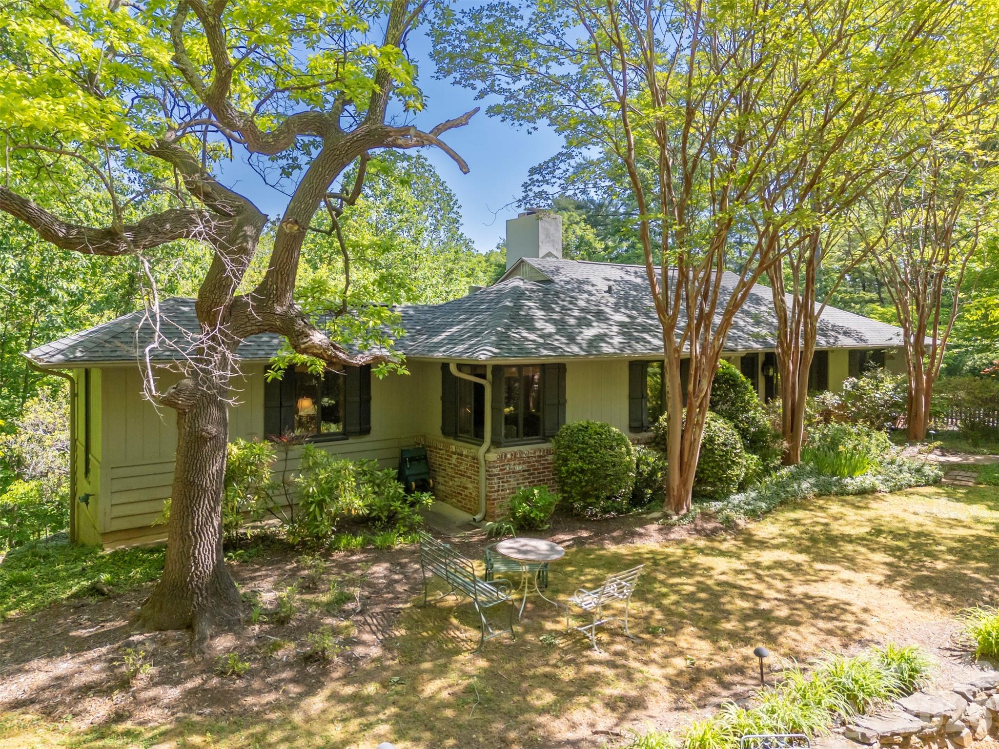 a view of a house with a tree in front of it