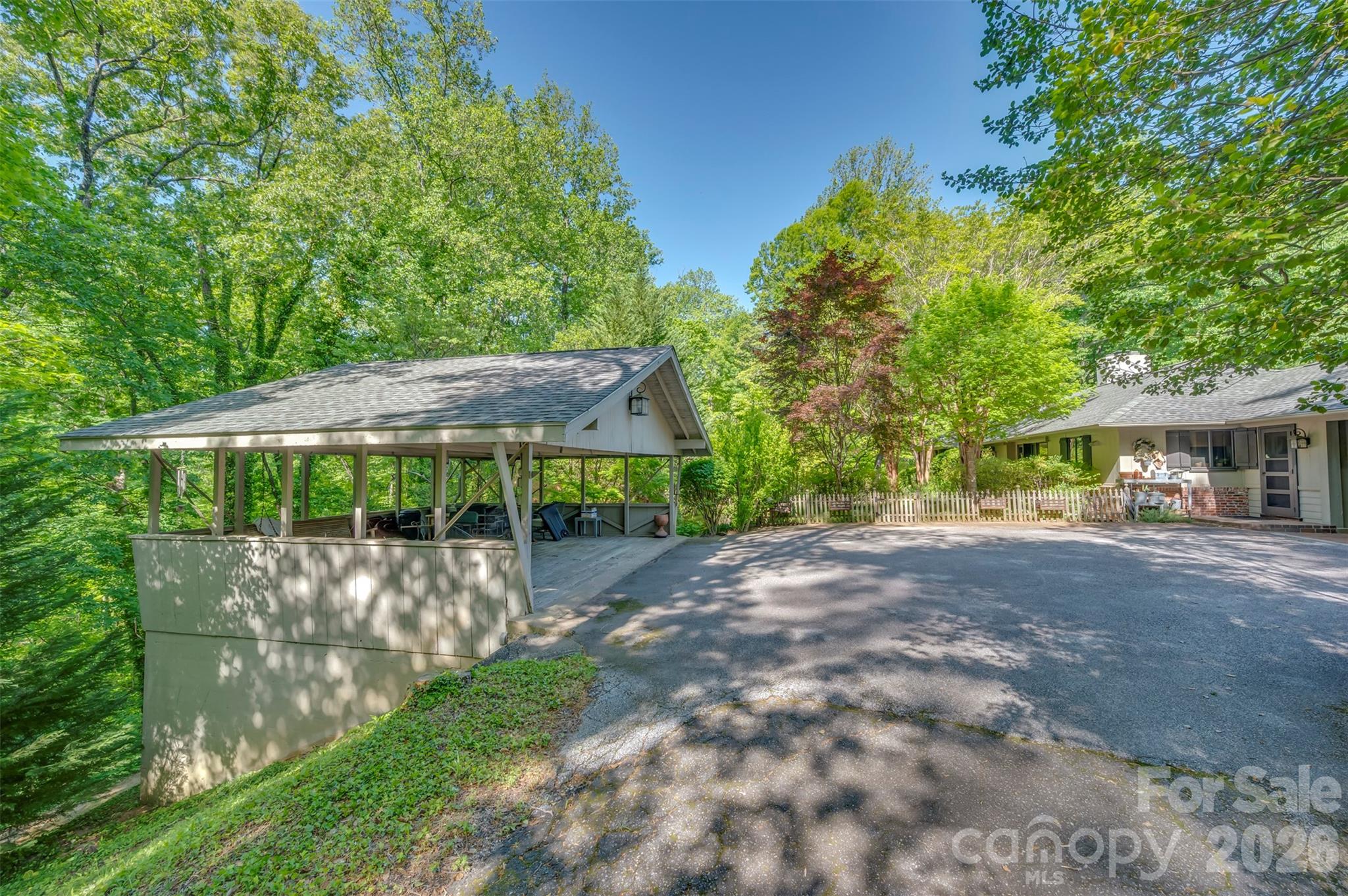 484 Sourwood Ridge Road Tryon, NC 28782 - Photo 28 of 34 a view of a patio with a table and chairs under an umbrella
