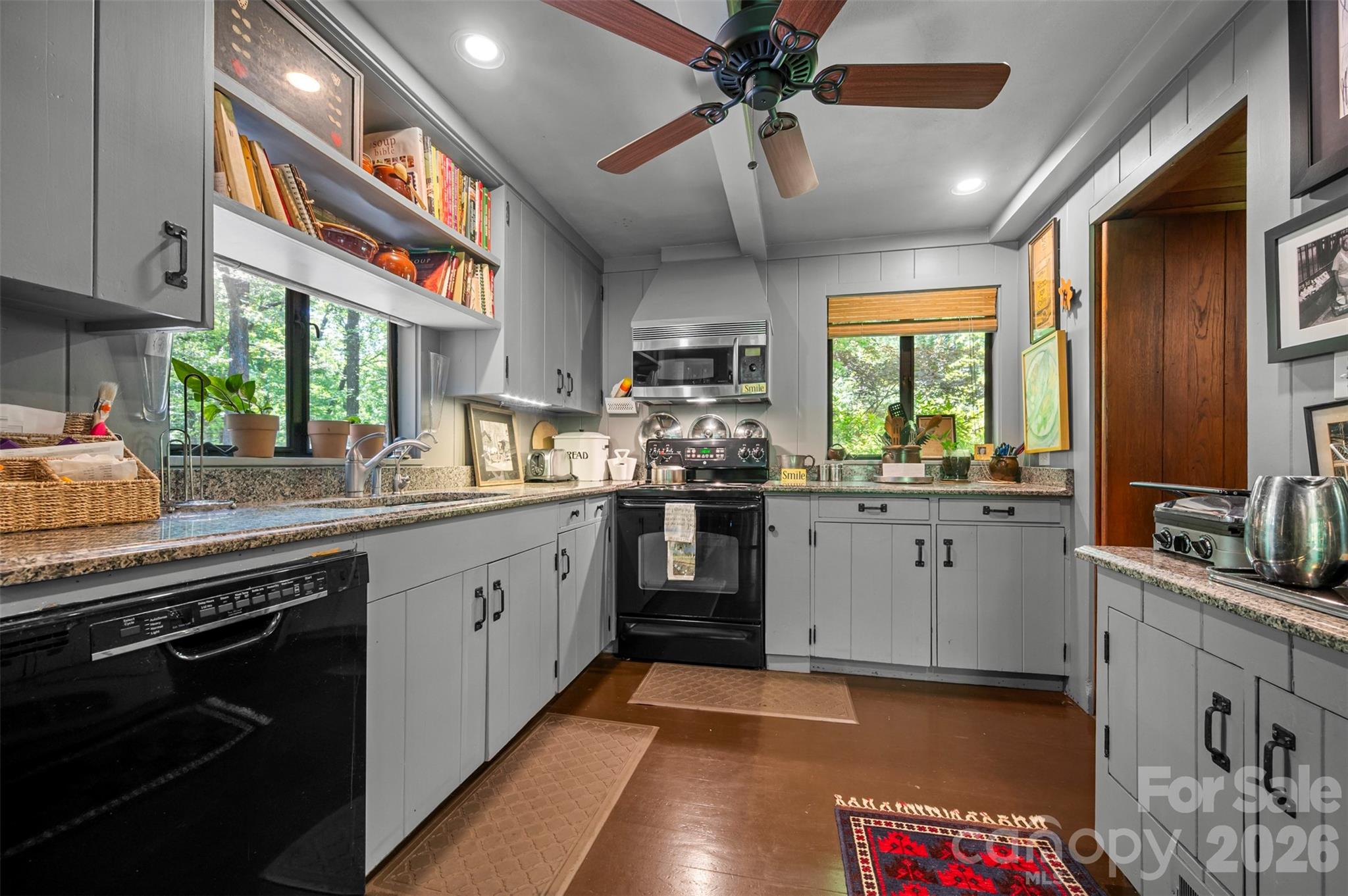 484 Sourwood Ridge Road Tryon, NC 28782 - Photo 8 of 34 a kitchen with stainless steel appliances kitchen island granite countertop a sink cabinets a stove and a window