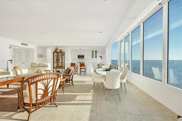 a dining room with furniture and large windows