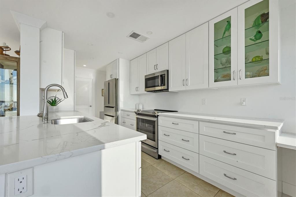 350 Golden Gate Point, Unit 62 Sarasota, FL 34236 - Photo 17 of 40 a kitchen with stainless steel appliances granite countertop a stove and a sink