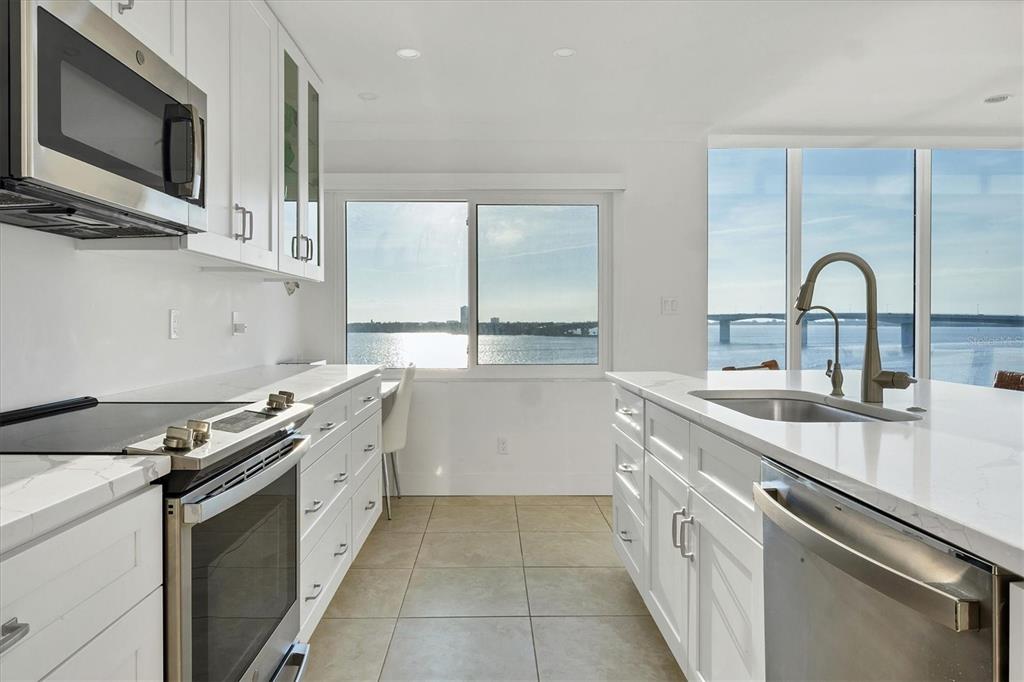 350 Golden Gate Point, Unit 62 Sarasota, FL 34236 - Photo 19 of 40 a kitchen with a sink stove top oven and cabinets
