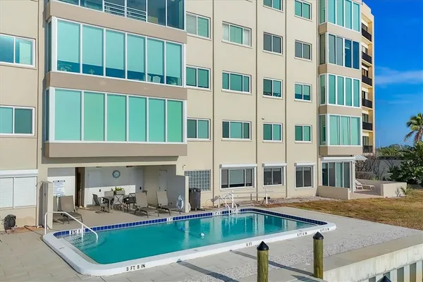 a front view of a building with swimming pool and outdoor seating