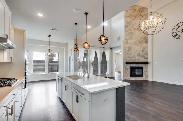 a large kitchen with a large island oven a stove and a wooden floors