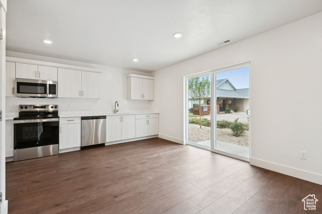 1615 North Angel Street, Unit I Layton, UT 84041 - Photo 19 of 56 Kitchen with stainless steel appliances, light countertops, dark wood-style flooring, recessed lighting, and white cabinetry