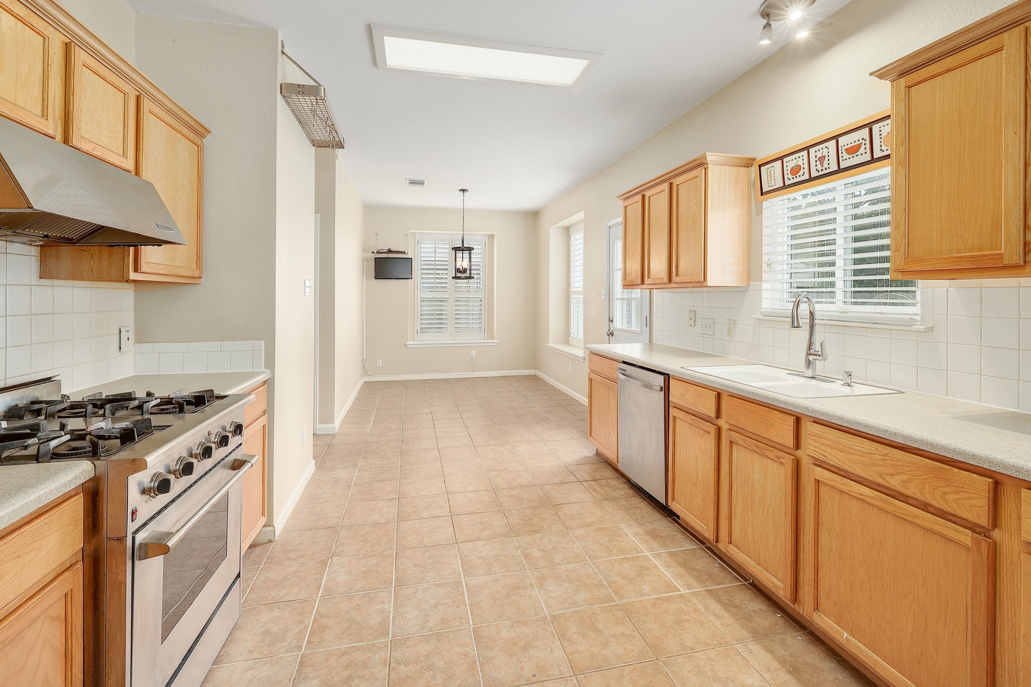 4615 Tello Path Austin, TX 78749 - Photo 8 of 31 Ample wooden cabinetry and tile floors define this long, functional culinary space.