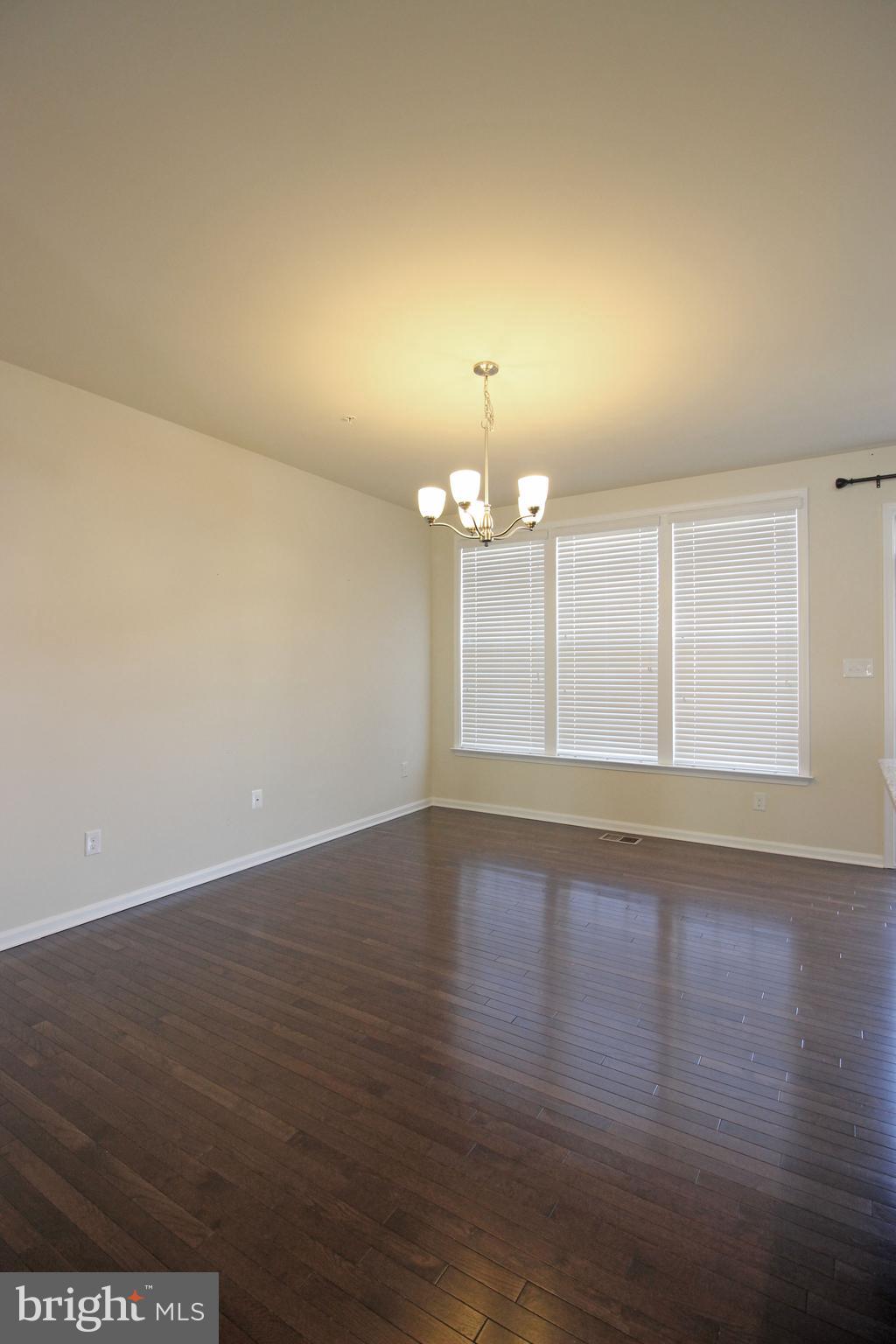 4720 Cambria Road Frederick, MD 21703 - Photo 12 of 41 an empty room with wooden floor and chandelier
