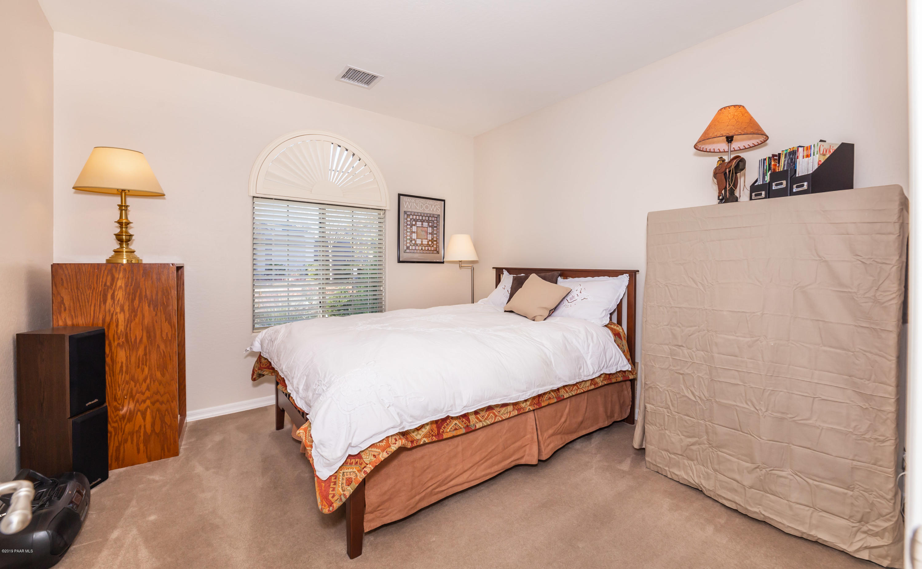 7258 Woolsey Ranch Road Prescott Valley, AZ 86314 - Photo 11 of 28 a spacious bedroom with a bed and a tv on the dresser