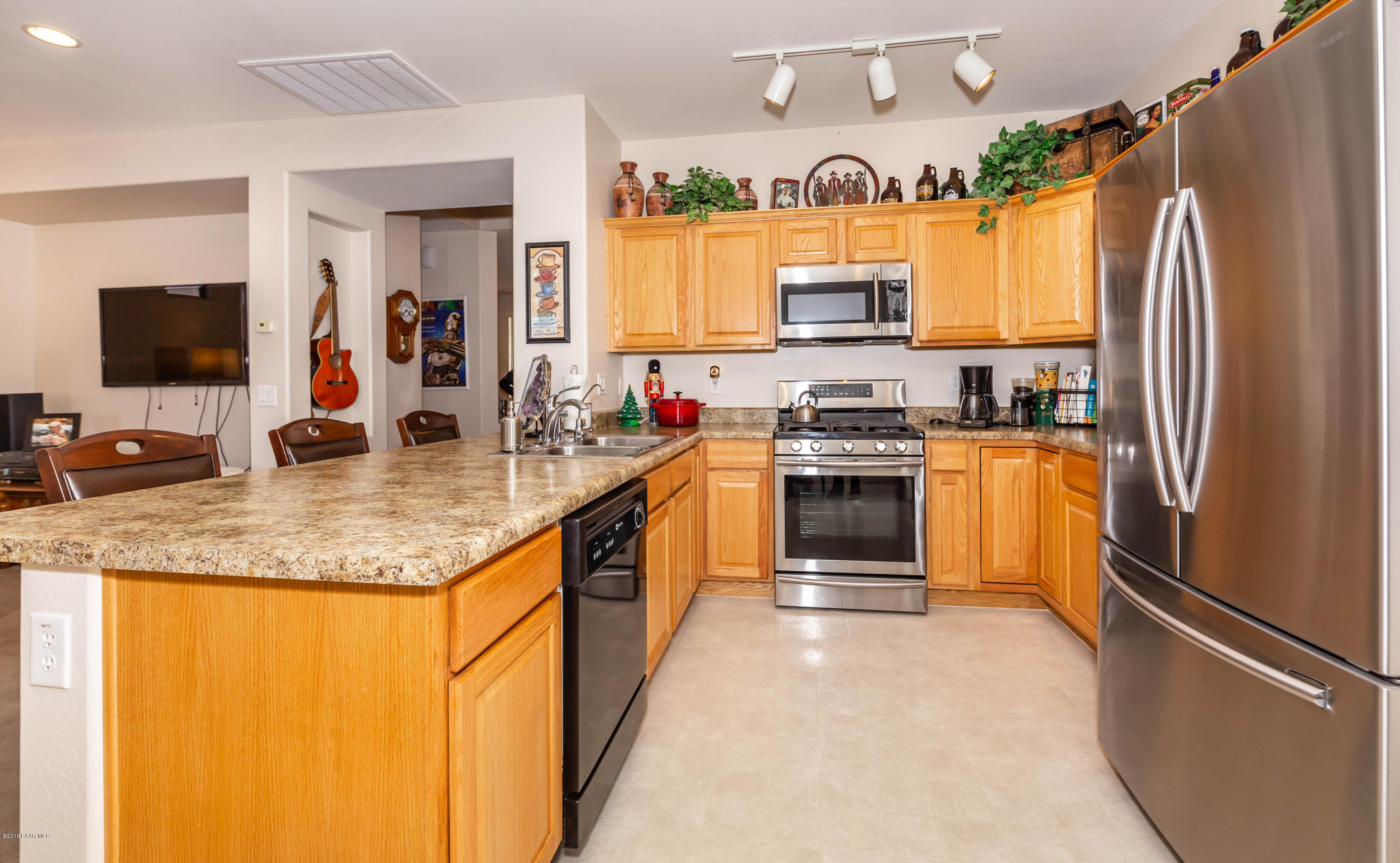 7258 Woolsey Ranch Road Prescott Valley, AZ 86314 - Photo 4 of 28 a kitchen with stainless steel appliances granite countertop a refrigerator a stove a sink and a microwave