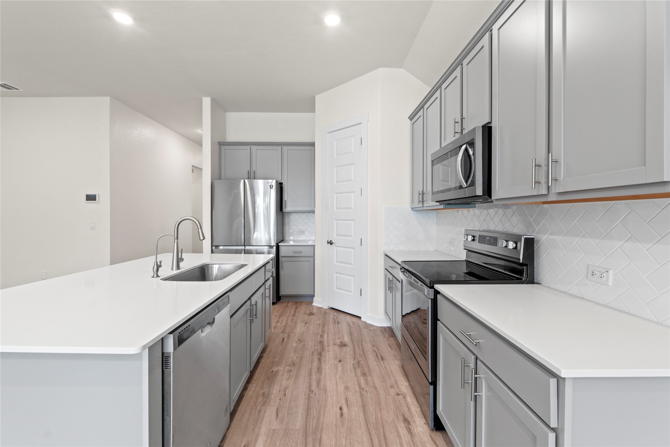 341 Peace Pipe Way Georgetown, TX 78628 - Photo 11 of 28 Quartz counters and stainless steel appliances give this eat-in kitchen an elegant look