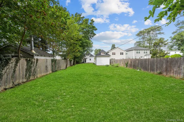 a view of a house with backyard and a tree