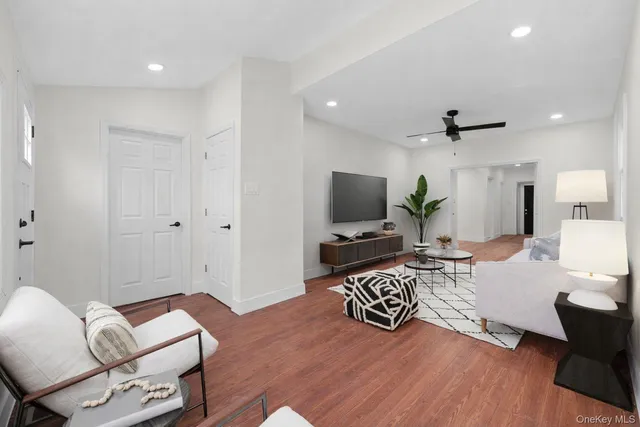 a living room with furniture a flat screen tv and a window