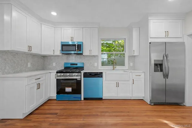 a kitchen with cabinets stainless steel appliances and a window