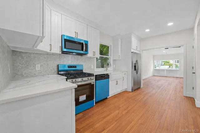 a kitchen with stainless steel appliances granite countertop a stove a sink and a refrigerator