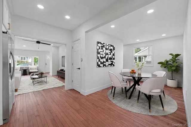 a view of a dining room with furniture a rug and wooden floor