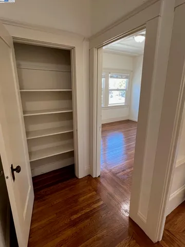 a view of walk in closet with wooden floor