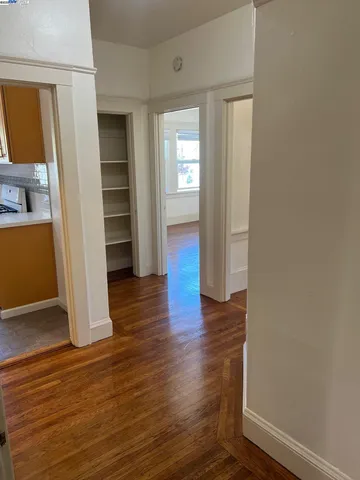 an empty room with wooden floor & windows and closet