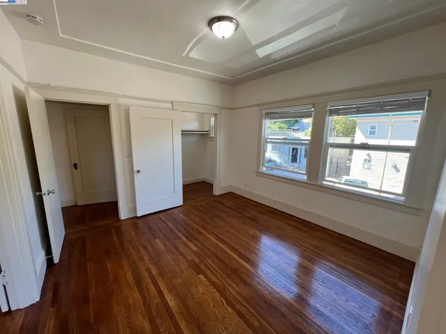 a view of an empty room window and wooden floor