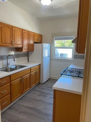 a kitchen with stainless steel appliances granite countertop wooden cabinets a stove a sink and a window