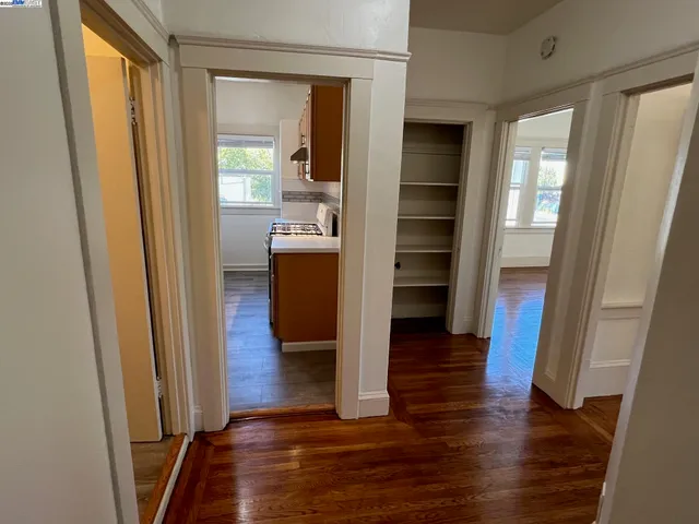 a view of a hallway with wooden floor and staircase