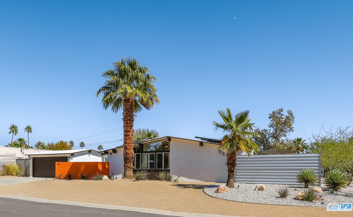 a palm tree sitting in front of a house