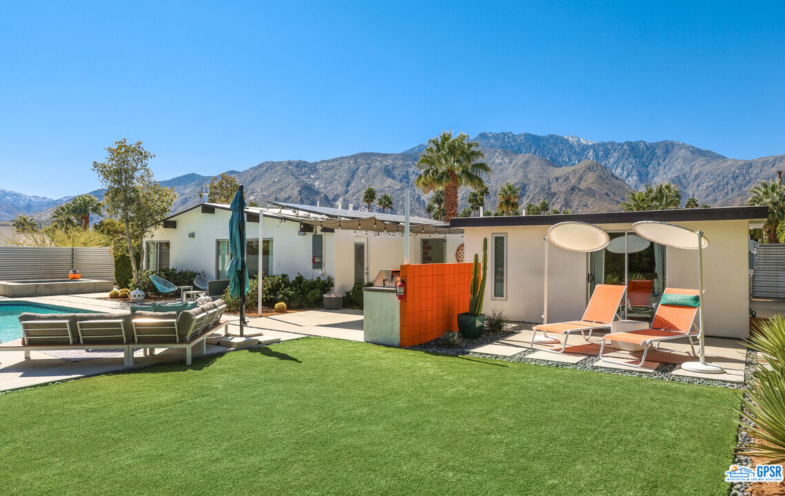 2108 George Drive Palm Springs, CA 92262 - Photo 23 of 33 a view of a backyard with table and chairs a barbeque and wooden fence