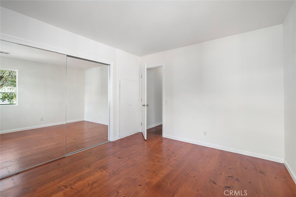 379 Harvey Street Cambria, CA 93428 - Photo 24 of 52 an empty room with wooden floor and windows