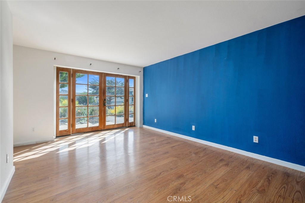 379 Harvey Street Cambria, CA 93428 - Photo 26 of 52 a view of an empty room with wooden floor and a window