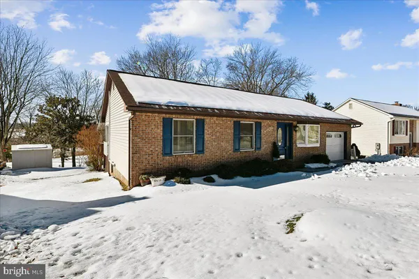 a front view of a house with a yard covered in snow