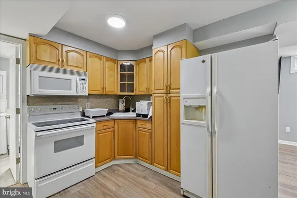 a kitchen with a refrigerator a sink and wooden cabinets