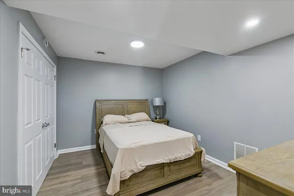 a bedroom with a bed and wooden floor