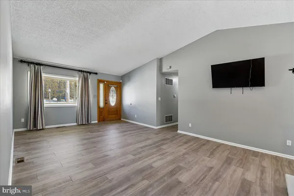a view of a livingroom with wooden floor and a flat screen tv