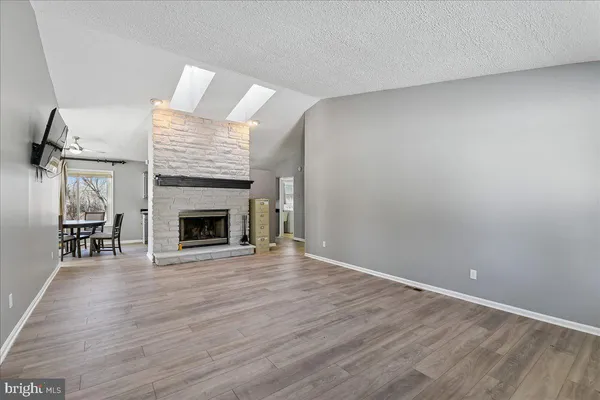 a view of empty room with wooden floor and fireplace