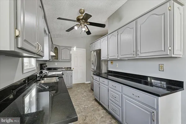 a kitchen with stainless steel appliances granite countertop a sink a stove and cabinets