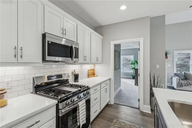a kitchen with stainless steel appliances a sink a stove and cabinets