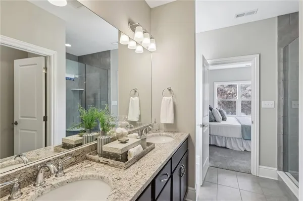 a en suite bathroom with a granite countertop sink a mirror and a vanity
