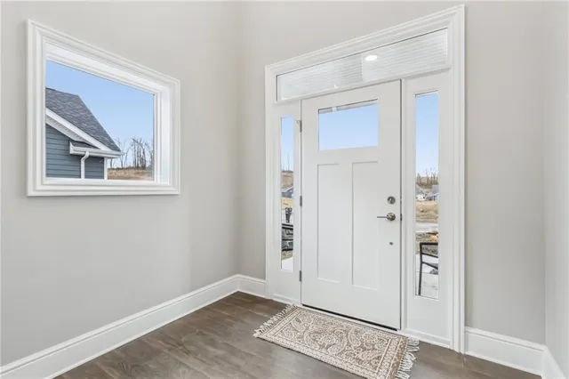 an empty room with wooden floor and mirror
